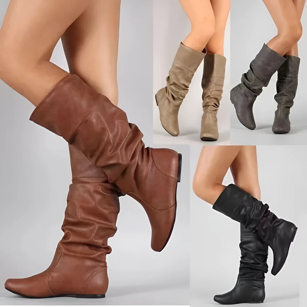 Women's black slip-on flat boots with round toe and high cylinder design on a neutral background.