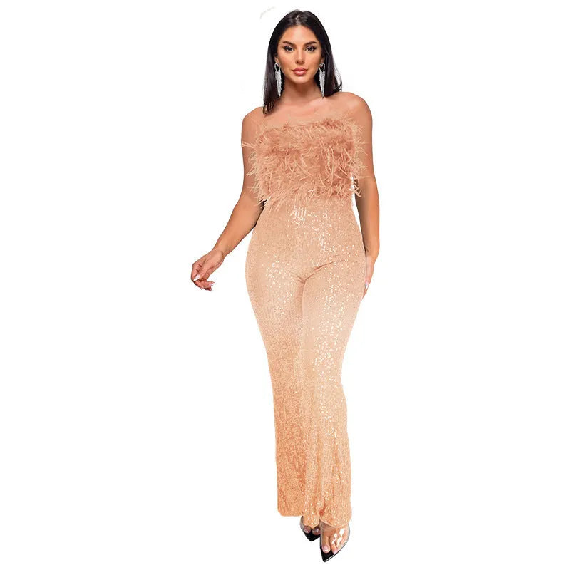 Woman wearing a black sleeveless backless jumpsuit with sequined top and flared legs.
