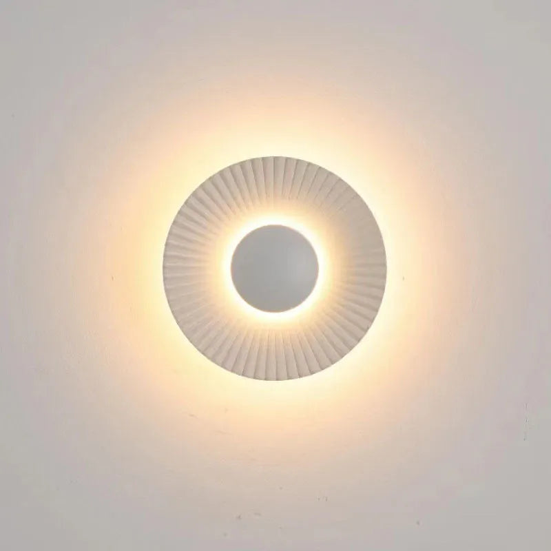 Round aluminium wall lamp with outer white and inner gold finish mounted on a wall