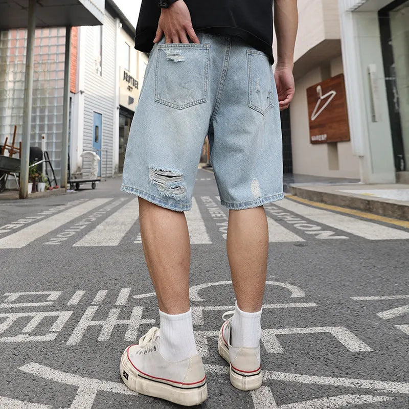 Light blue ripped denim shorts with distressed details and straight leg cut in hip hop streetwear style