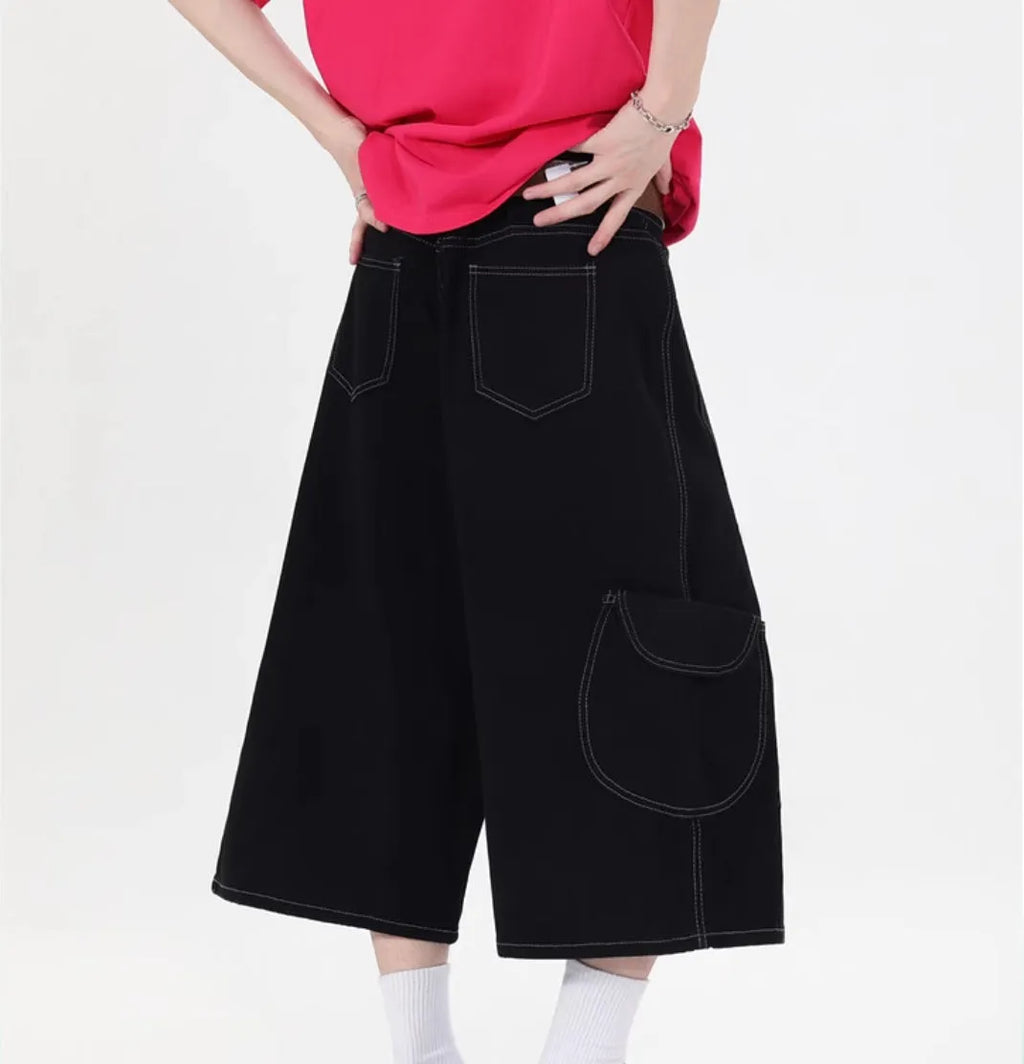 Red retro denim shorts with wide leg and multiple pockets laid flat.