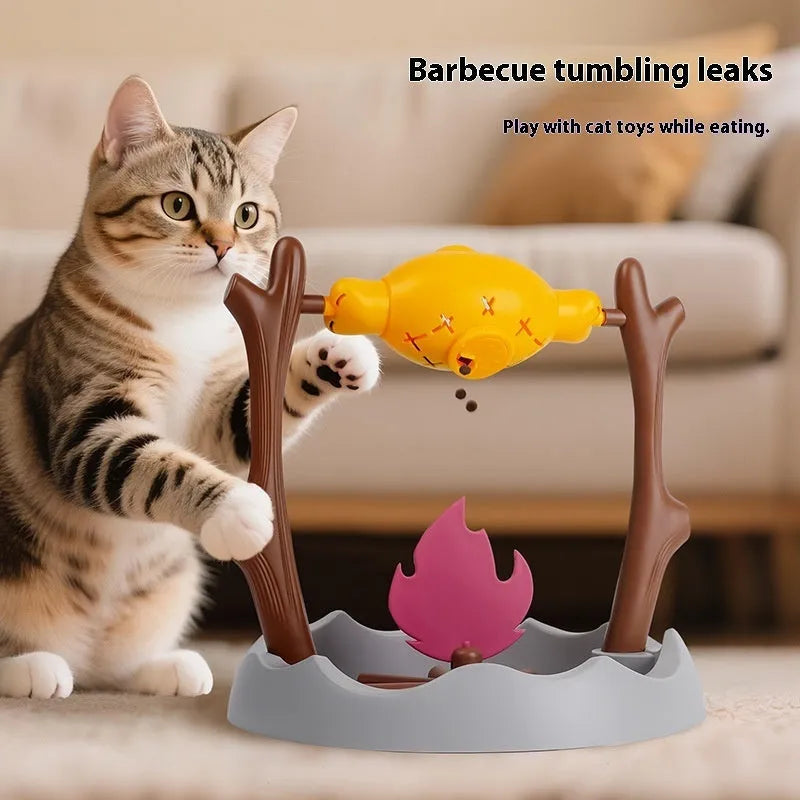 White and grey tumbling cat feeder toy with treat compartment on a wooden floor.