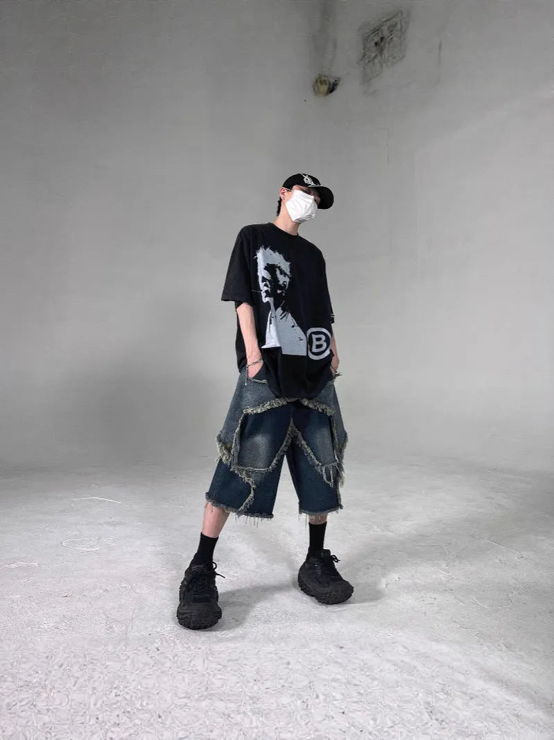 Men's blue distressed denim shorts with a large five-pointed star and frayed hem in a loose cargo fit.
