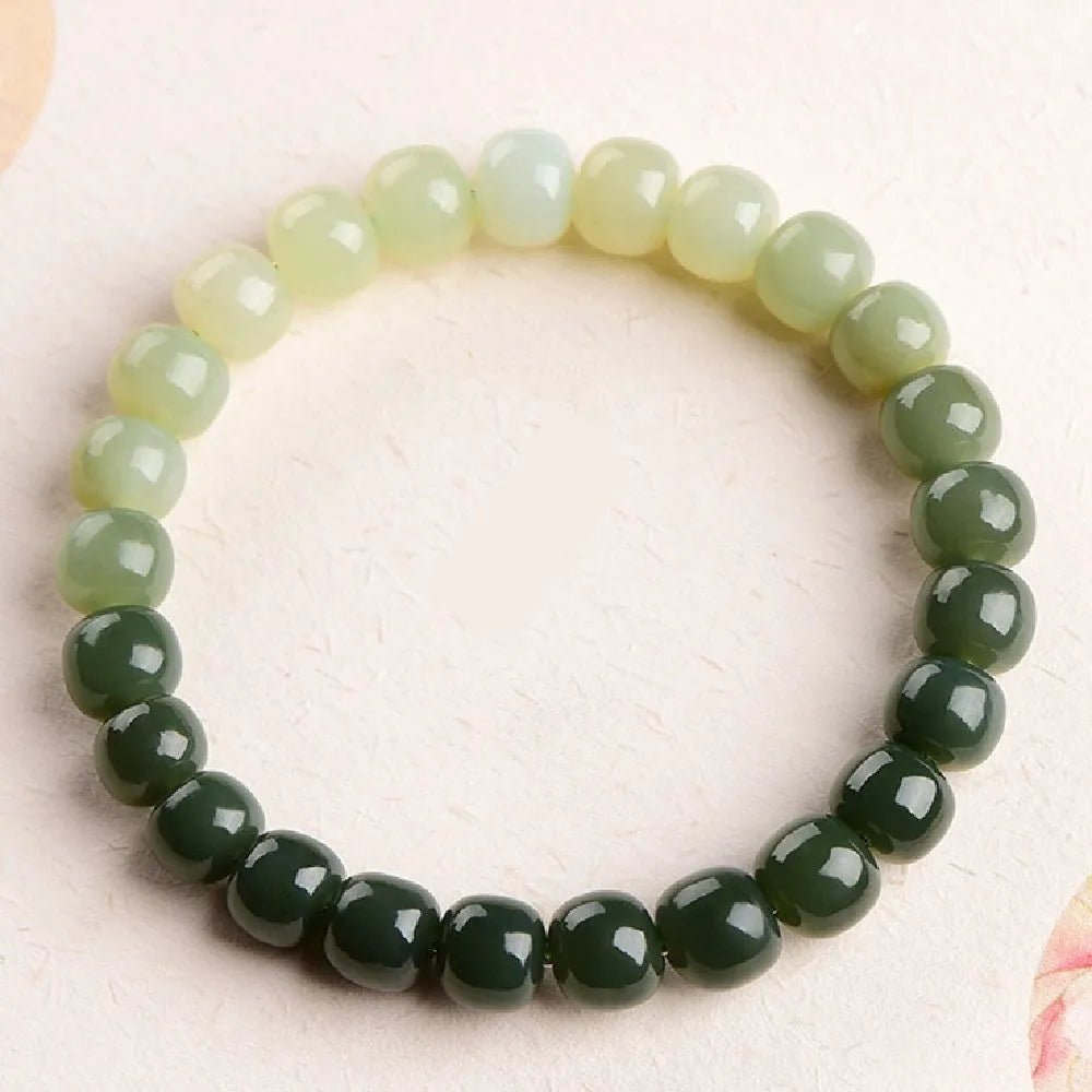 Natural Hetian Jade bracelet showing water gradient colour on wrist, with polished beads.