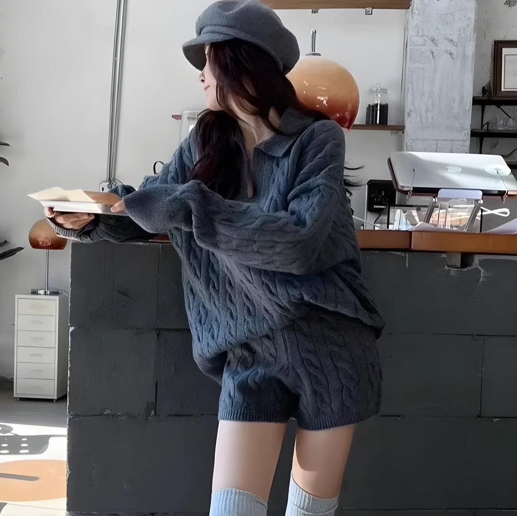 Women's knitted suit set showing geometric pattern cable knit sweater and elastic waist shorts in black colour