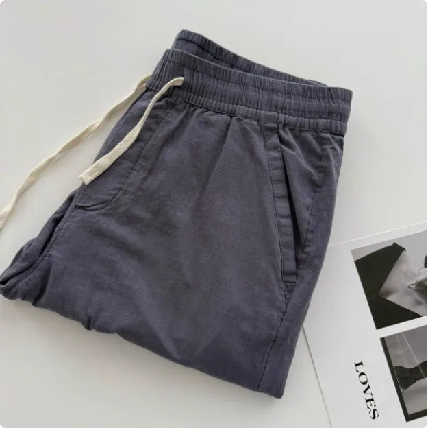 Men's beige loose-fit straight-leg casual pants with a drawstring waistband on a hanger.
