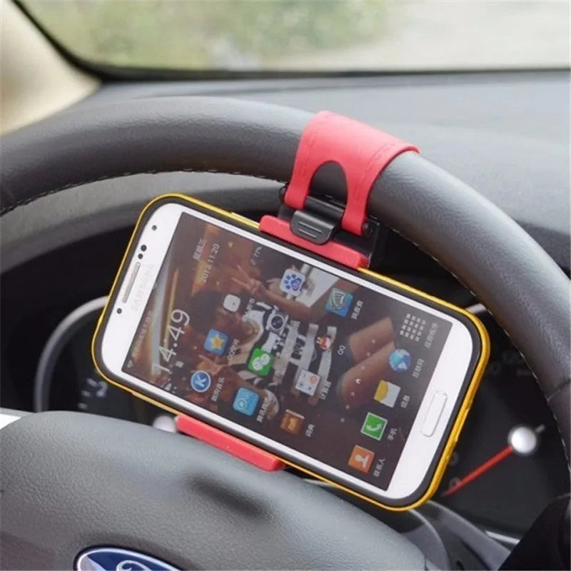 Black steering wheel phone holder clip mounted on car steering wheel holding a smartphone
