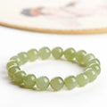 Polished Hetian jade ball bead bracelet in light and deep clear water colours on a wrist.