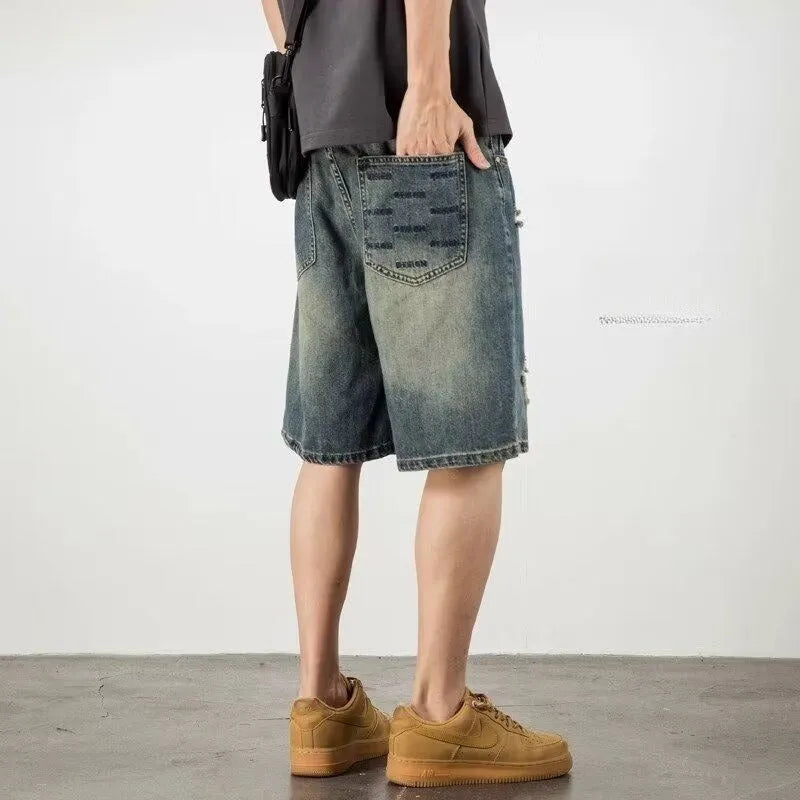 Men's blue distressed denim shorts with a straight leg and retro hole detailing.