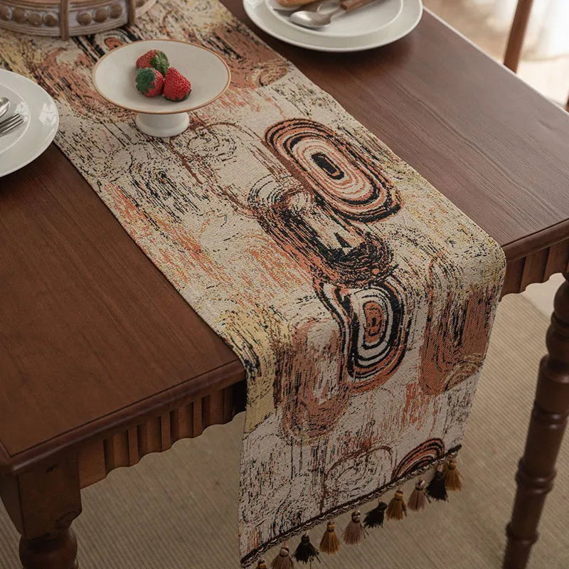 Dark blue striped Nordic jacquard bouquet table runner with tassel trim laid flat on a table.