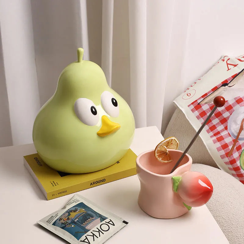 A cute pear-shaped white ceramic tissue box holder with an animal design, shown in green and black colour options.