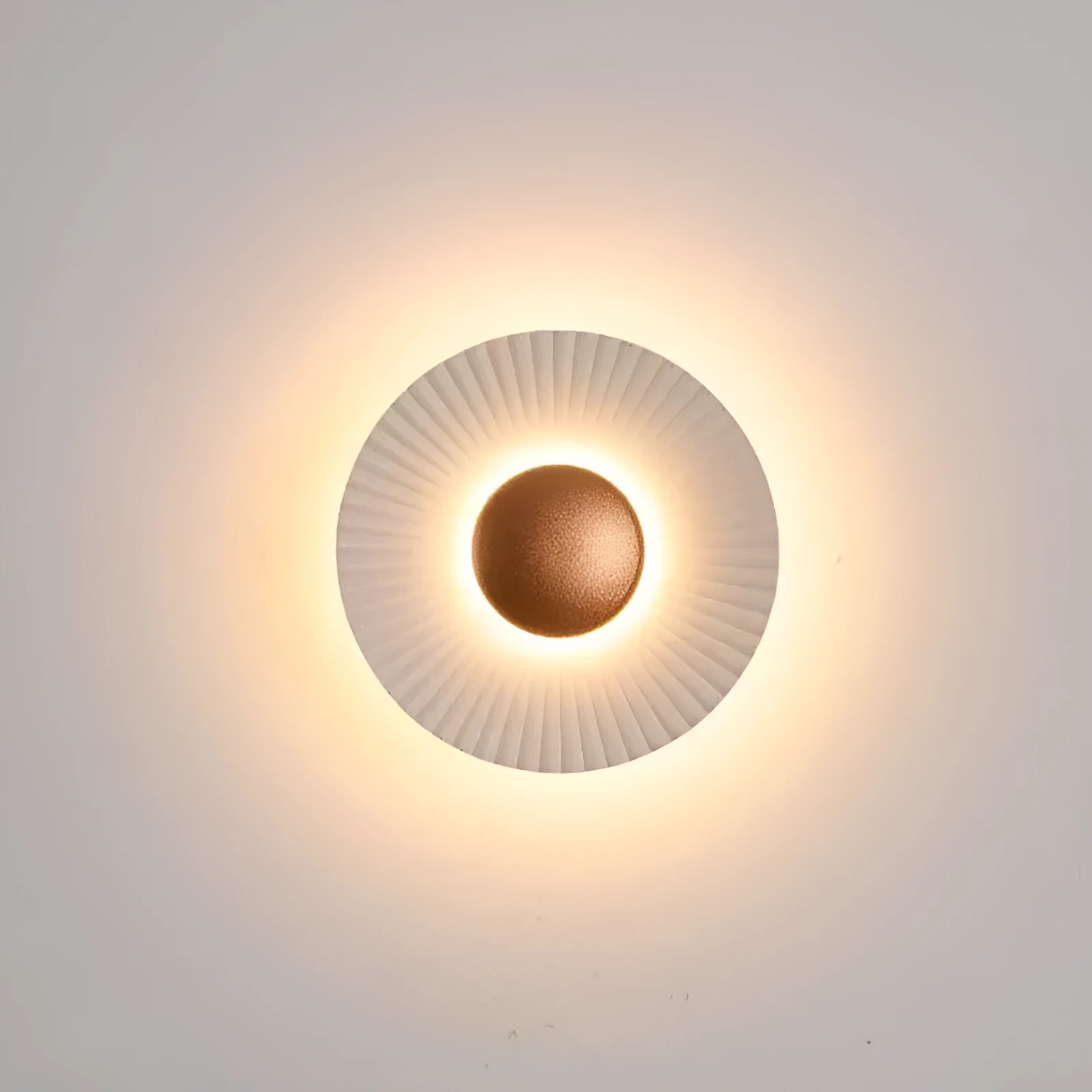 Round aluminium wall lamp with outer white and inner gold finish mounted on a wall