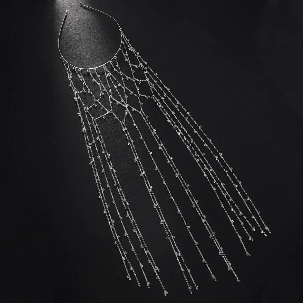 Close-up of a gold metallic mesh headband with rhinestone details and hanging tassels.