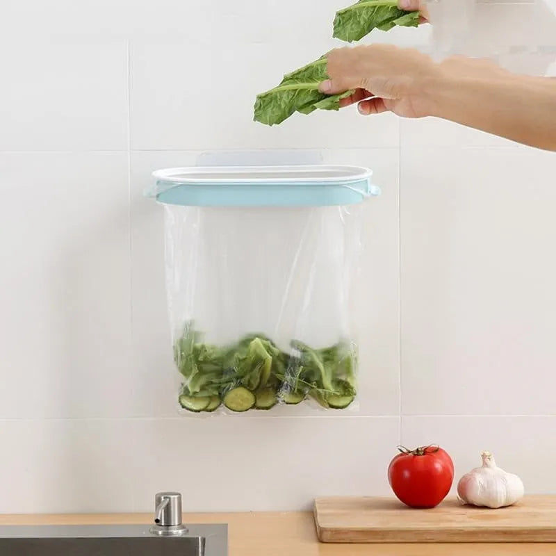 Blue plastic kitchen bin bag storage rack mounted on a cabinet door holding a roll of bags.