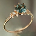 Gold geometric ring with claw-set zircon stones and chamfered square patterns