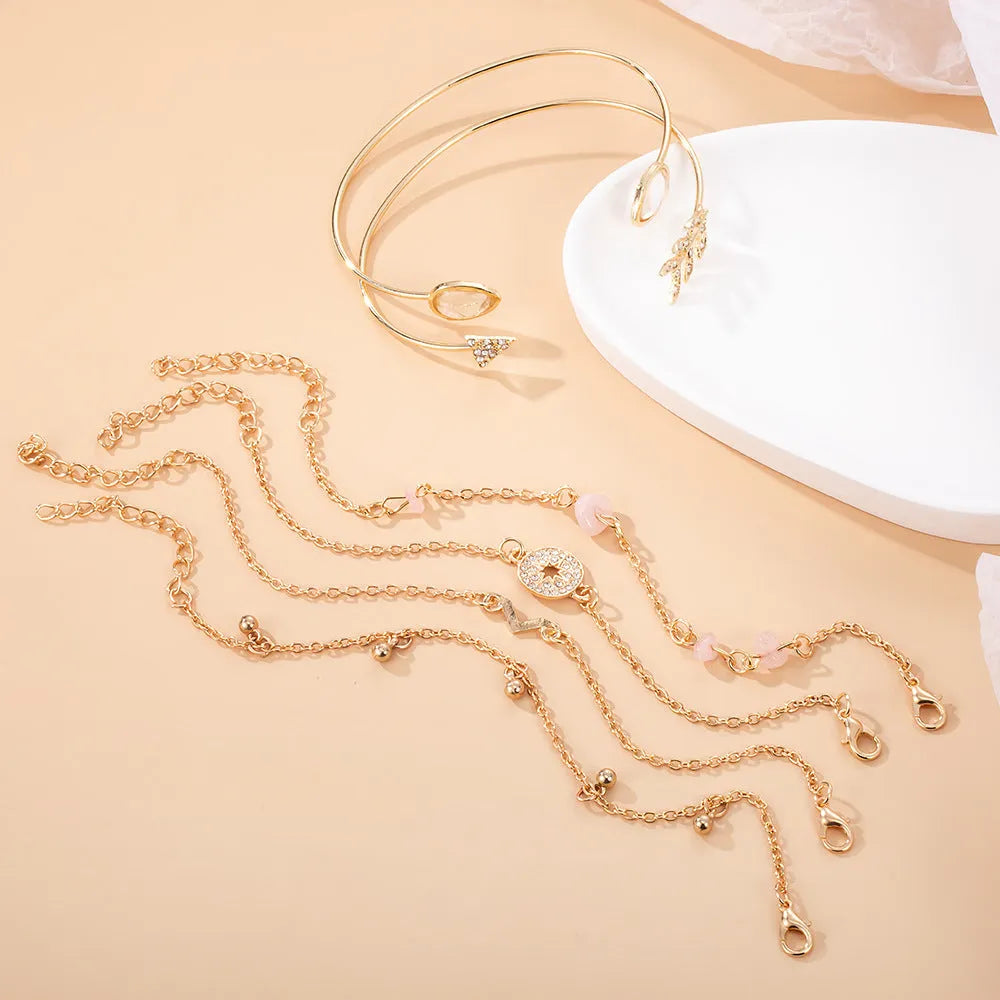 Gold-coloured six-piece women's bracelet set with arrow, water drop, and V-shaped charms on a white background.