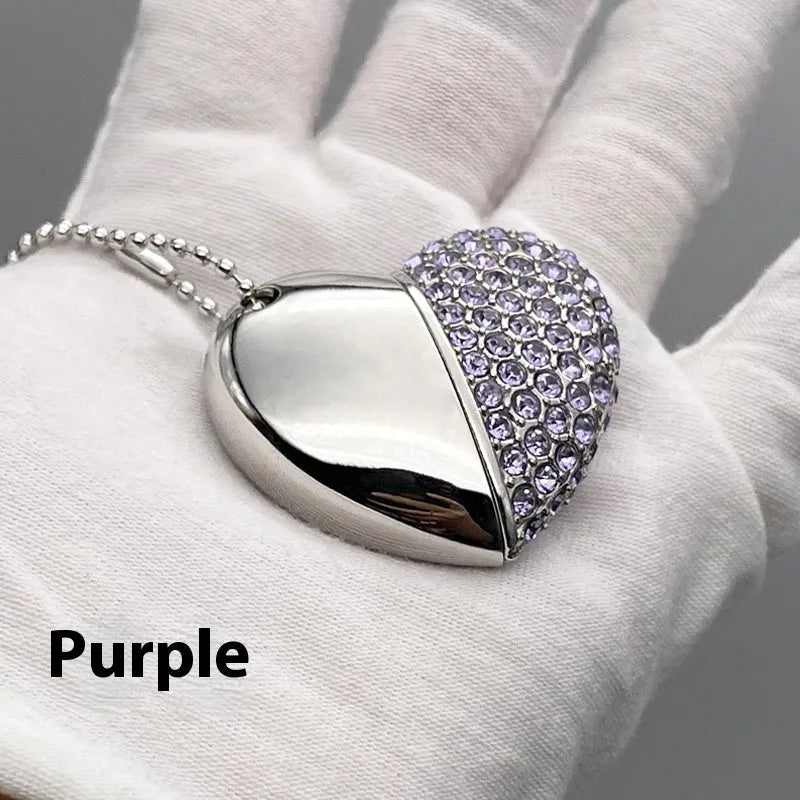 A heart-shaped silver USB flash drive with a brick pattern, shown next to a laptop.