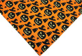 Reversible Halloween dog bandana showing pumpkin and spider web designs in black and orange colours with adjustable neck closure