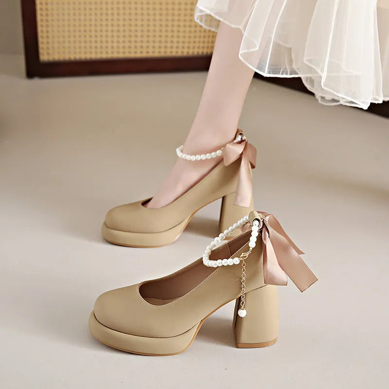 Women's beige Mary Jane shoes with chunky heel, round toe, and ankle strap with pearl buckle.