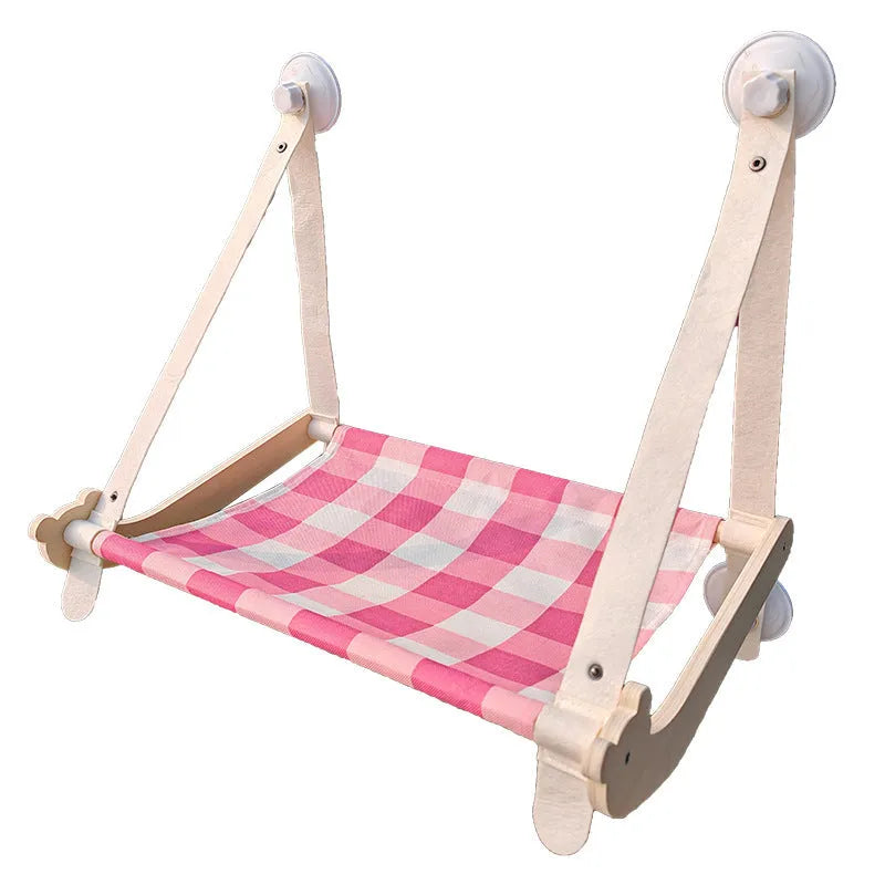 Wooden frame cat hammock with linen cushion mounted on a window, shown in green colour.