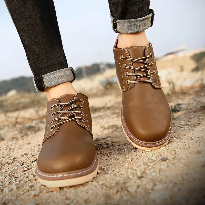 Men's black mid-top leather-style boots with rubber sole showing waterproof non-slip design