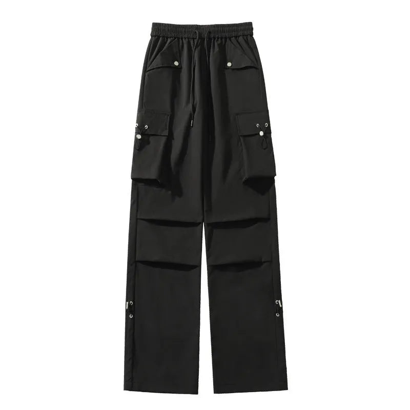 A woman wearing thin, loose, straight-leg waterproof trousers in a solid colour with an elastic drawstring waist.