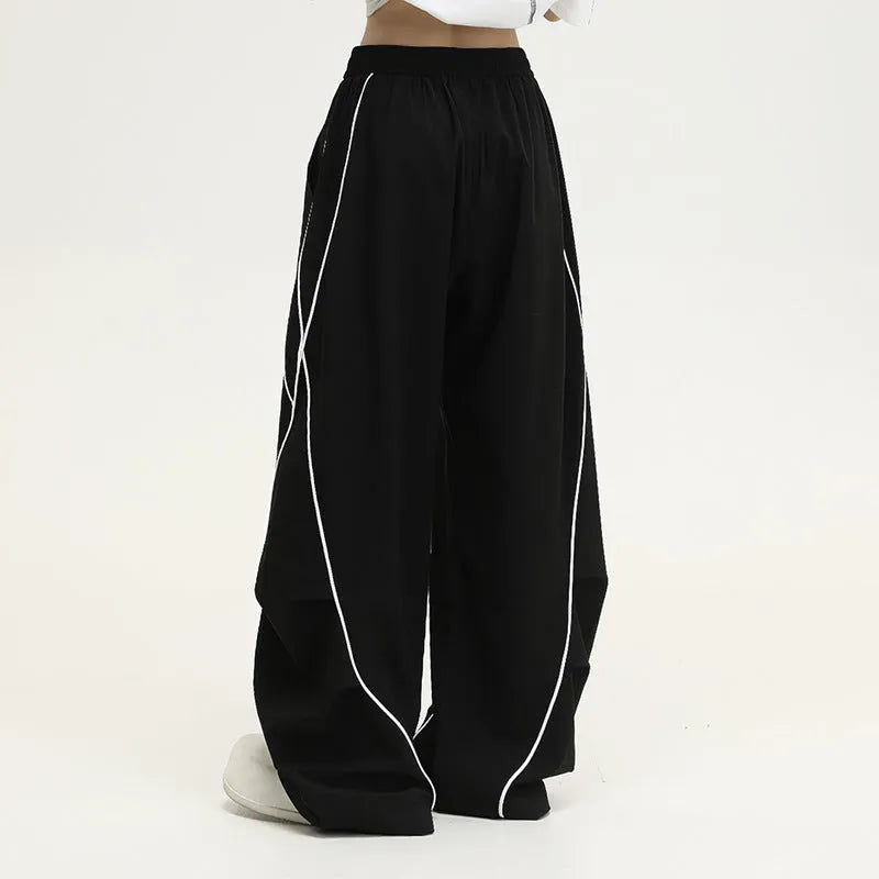 Black pleated hip hop wide-leg pants with stripe pattern showing mid-waist and loose fit