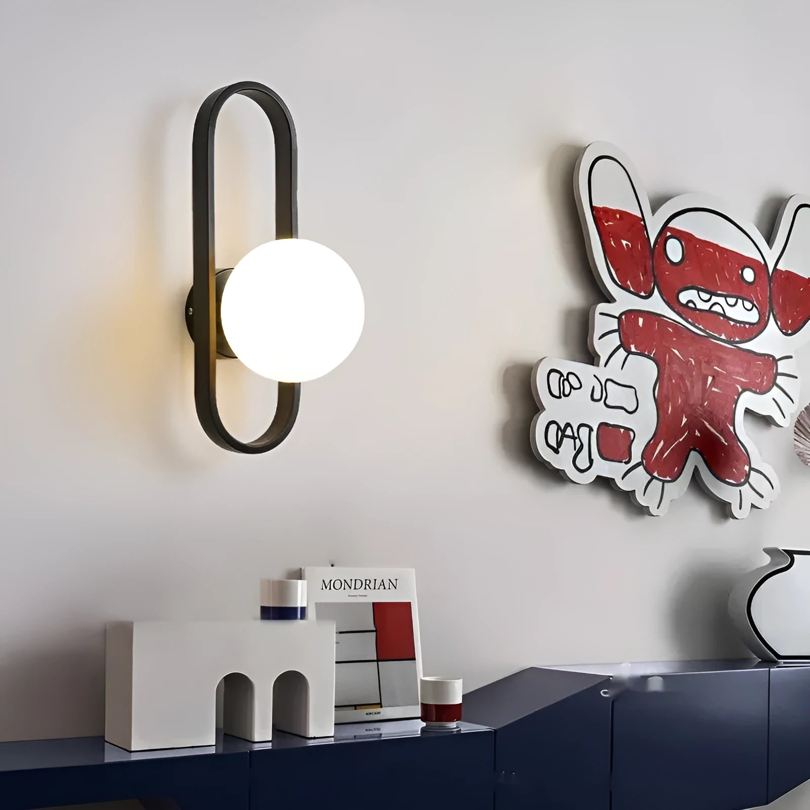 Minimalist modern wall lamp with glass shade and iron body in black finish, mounted on a wall.