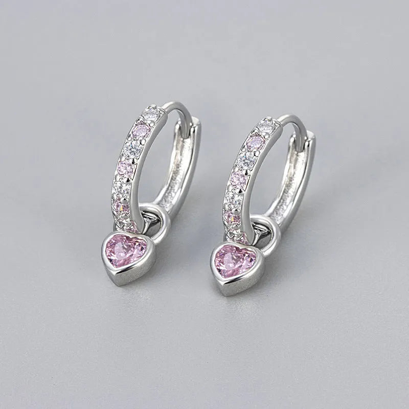 Women's fashion earrings with heart-shaped drops containing coloured gemstones in gold or white gold colour settings