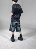 Men's blue distressed denim shorts with a large five-pointed star and frayed hem in a loose cargo fit.