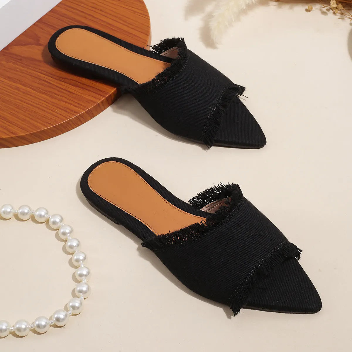 Women's denim flat slippers with tassel detail and leather lining in various colours.