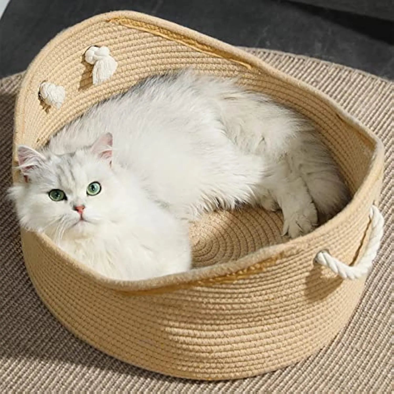 A rectangular wicker cat bed basket with a corrugated cardboard scratching surface on its side.