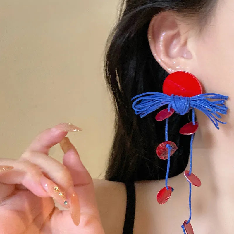 Women's geometric earrings with blue resin flowers on cloth material featuring silver needle elements