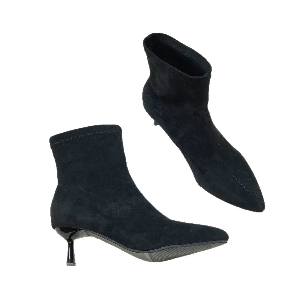 Black pointed toe ankle boots with a high stiletto heel on a woman's foot.