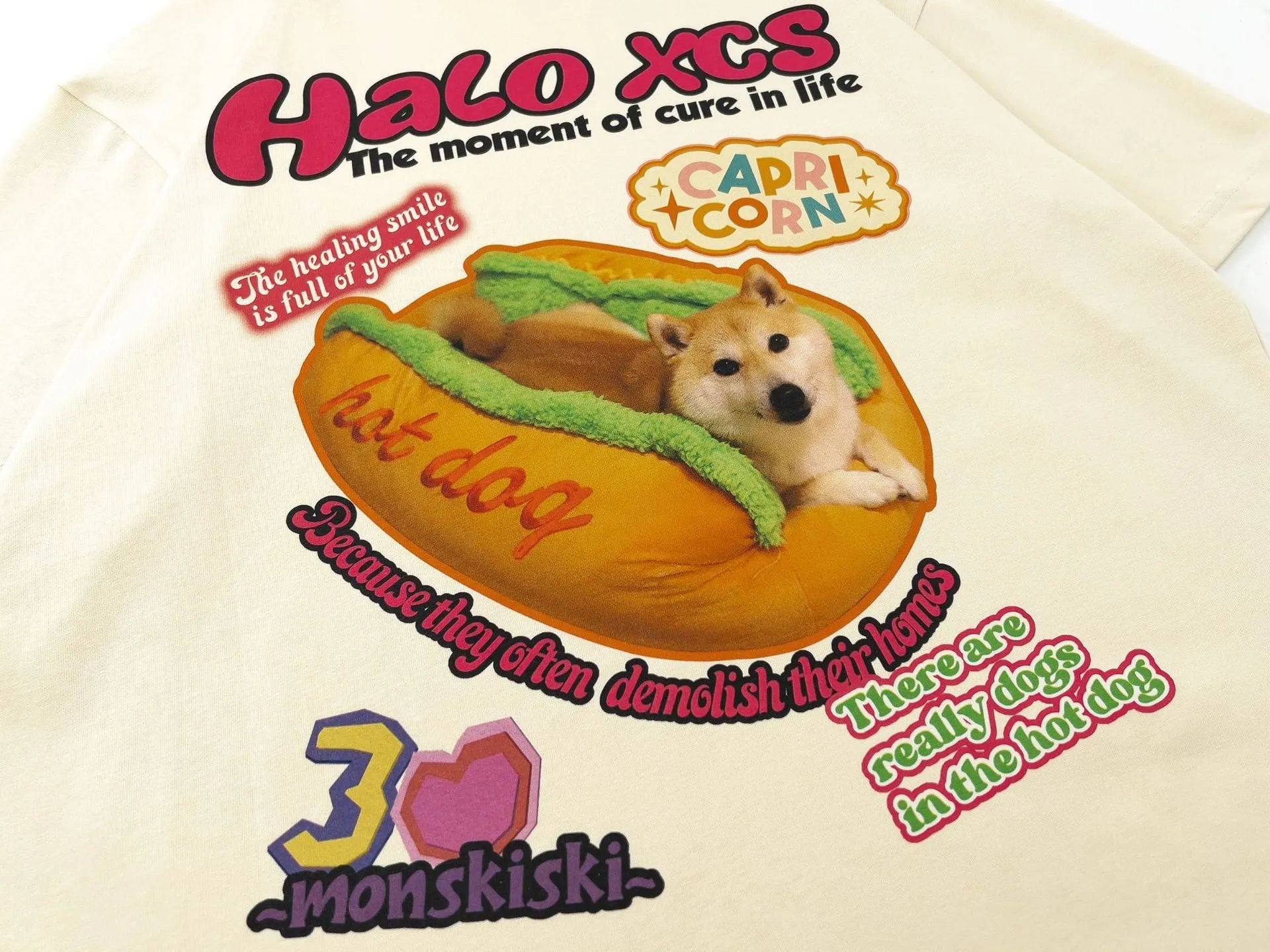 White short-sleeved cotton t-shirt with a cartoon hamburger dog graphic print, shown on a model.