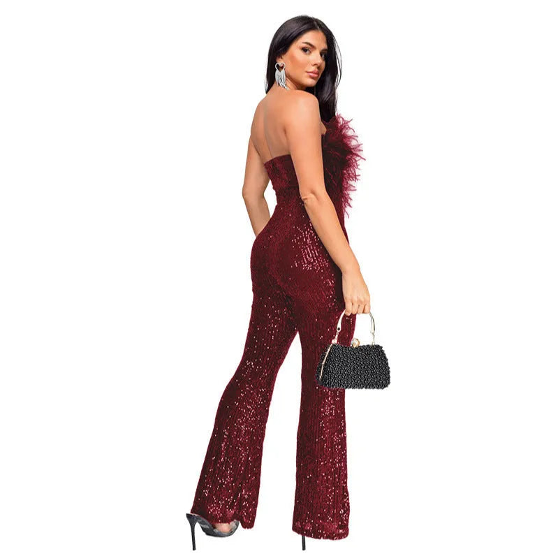 Woman wearing a black sleeveless backless jumpsuit with sequined top and flared legs.