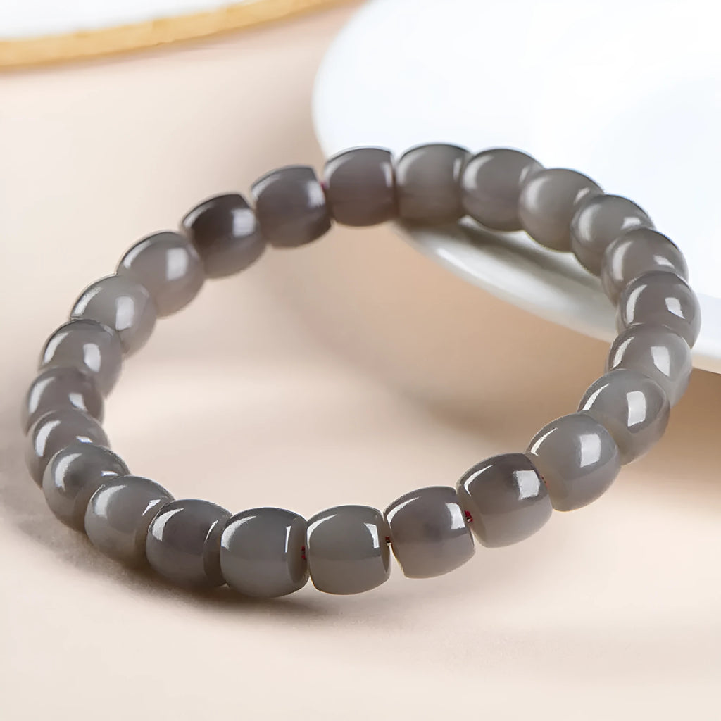 Smokey violet Hetian jade straight cut bead bracelet on a wrist.