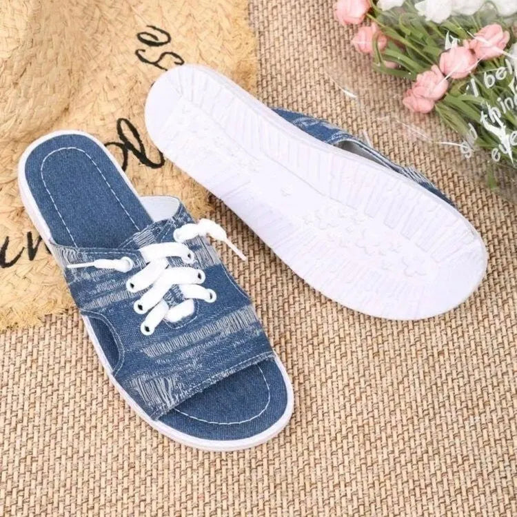 Blue women's flat canvas Roman style slippers with a cloth upper and rubber sole.