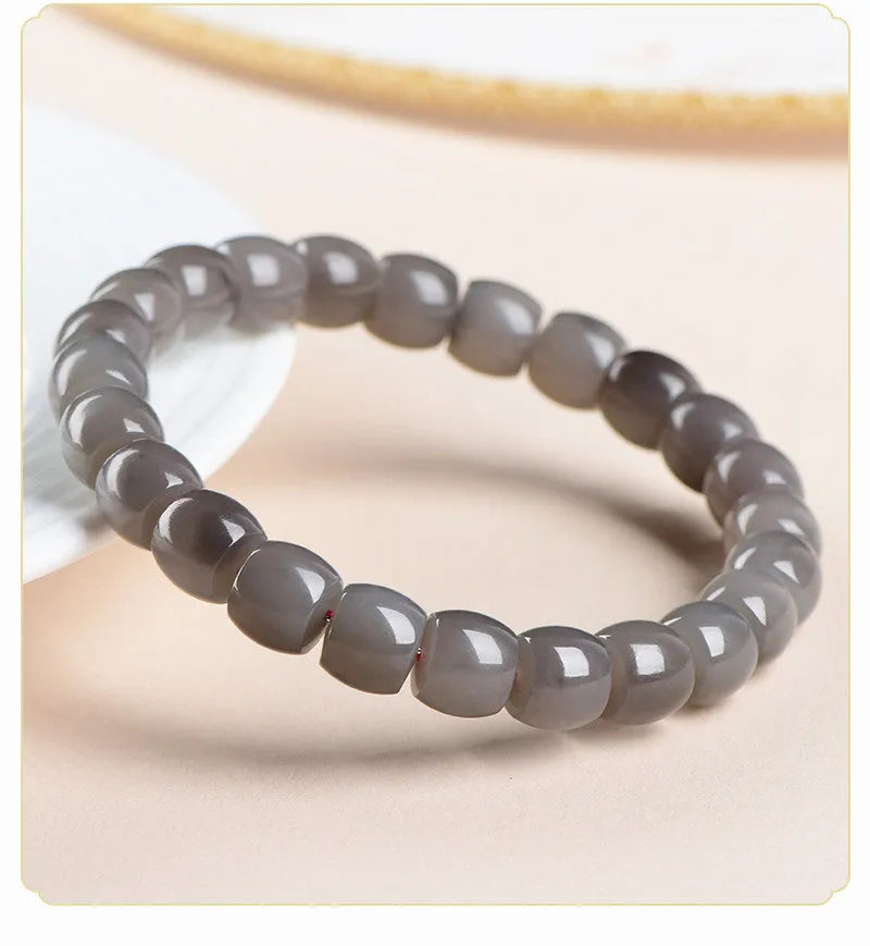 Smokey violet Hetian jade straight cut bead bracelet on a wrist.