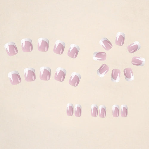 24 white false nail tips with a plaid pattern, laid out on a surface