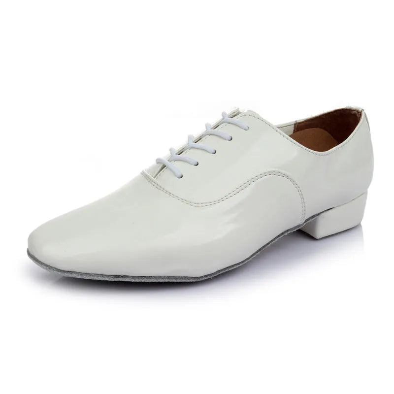 Men's black dancing shoes with a synthetic leather upper and calf leather sole, shown on a studio floor.