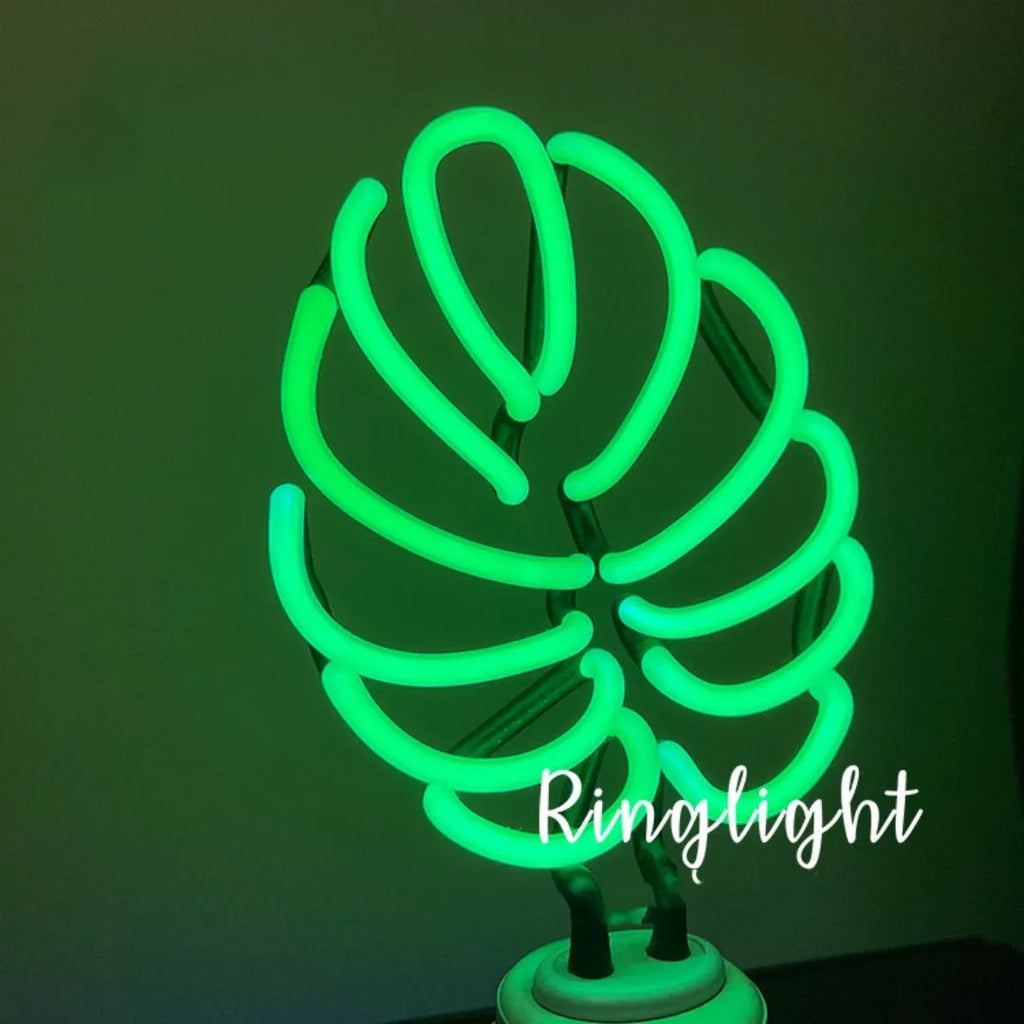 Minimalist white bamboo-shaped desk lamp emitting a soft green LED light, with a black USB cable.