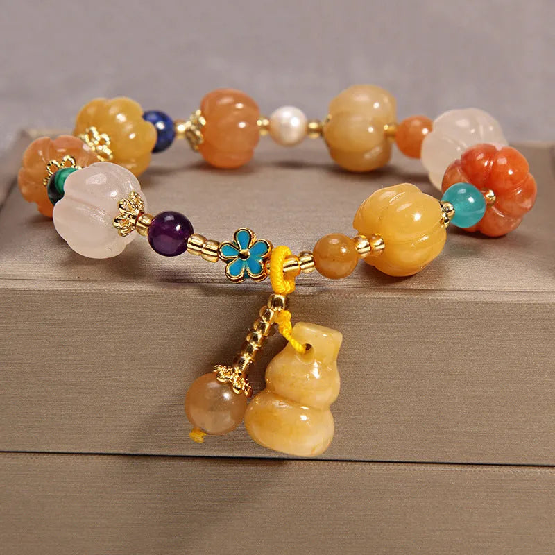 Yellow agate crystal bracelet with gold silk cord and adjustable sliding knot on a wrist.