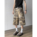 Yellow women's cropped jeans with a large snake camouflage pattern tooling print on the denim fabric.