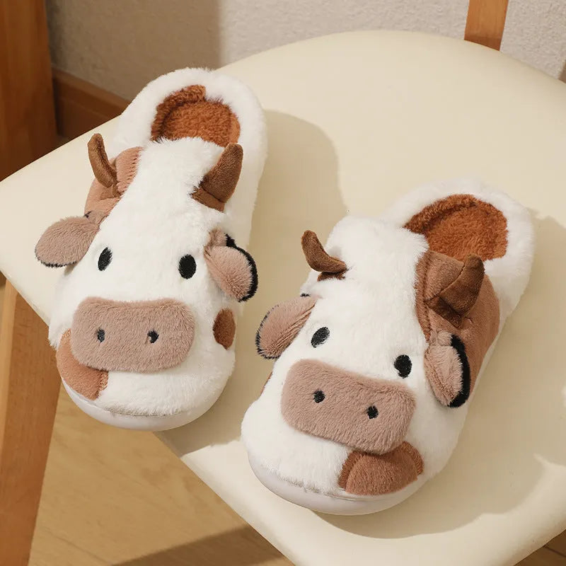 White cow plush slippers with non-slip textured soles shown from above