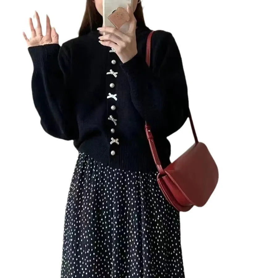 Women's solid colour cashmere cardigan with bow detail and pearl buttons on a hanger