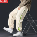 Man wearing loose grey-green trousers with stitching print detail and ankle banding.