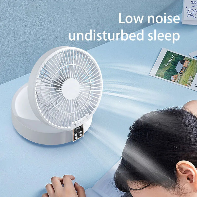 White portable folding desk fan with remote control and warm night light on a table