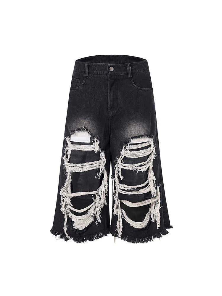 Black women's cropped wide leg jeans with a distressed patch detail on the leg.