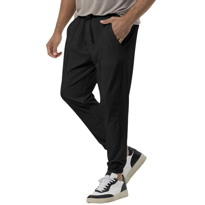Men's grey casual tapered sweatpants with an elasticated waistband laid flat.